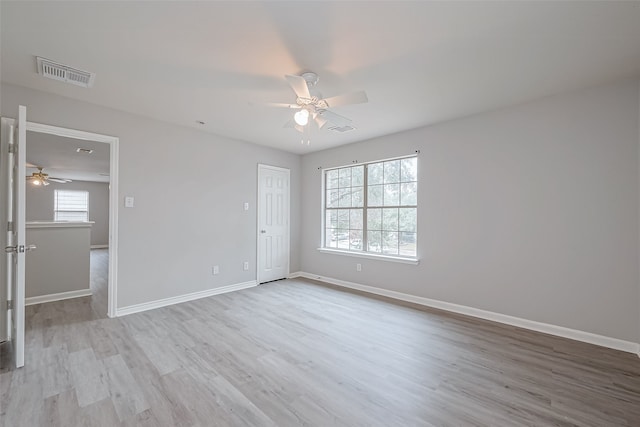 empty room with ceiling fan and light hardwood / wood-style flooring