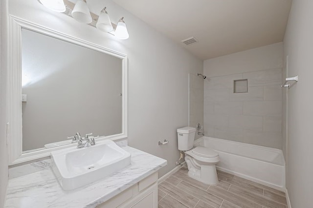 full bathroom with vanity, toilet, and tiled shower / bath