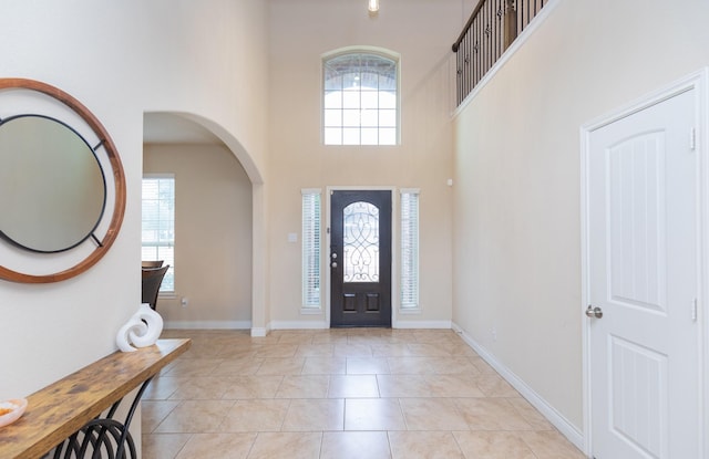 tiled entryway featuring a towering ceiling