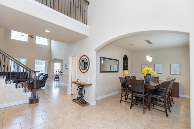 tiled dining room featuring a towering ceiling