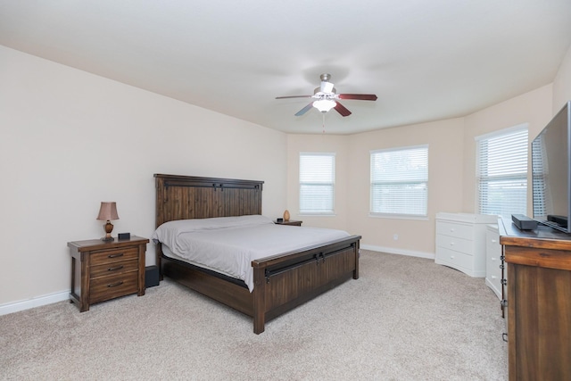 bedroom with multiple windows, light colored carpet, and ceiling fan