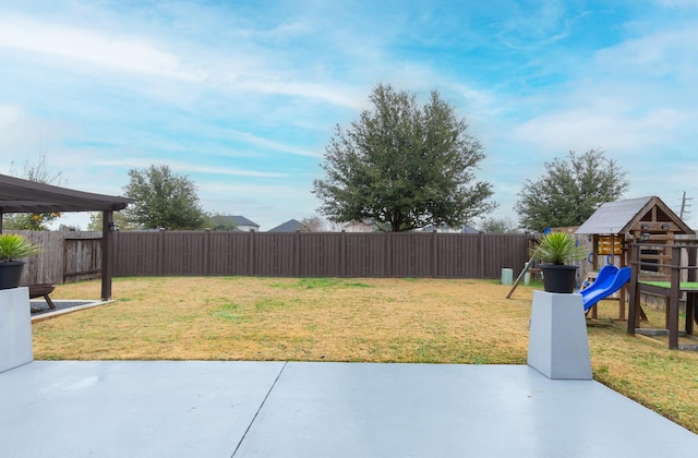 view of yard featuring a playground and a patio