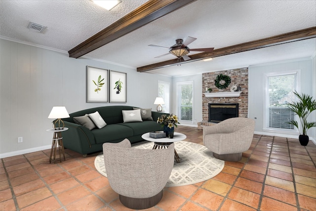 living room with a brick fireplace, a healthy amount of sunlight, a textured ceiling, and beam ceiling