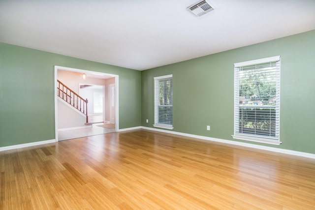 empty room with plenty of natural light and light hardwood / wood-style flooring