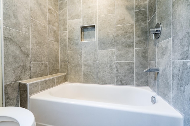 bathroom featuring toilet and a washtub