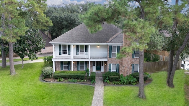 view of front of property with a porch, a balcony, and a front lawn