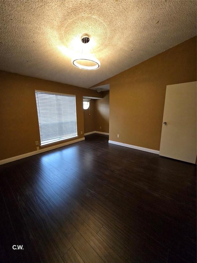 unfurnished room with dark wood-type flooring and a textured ceiling