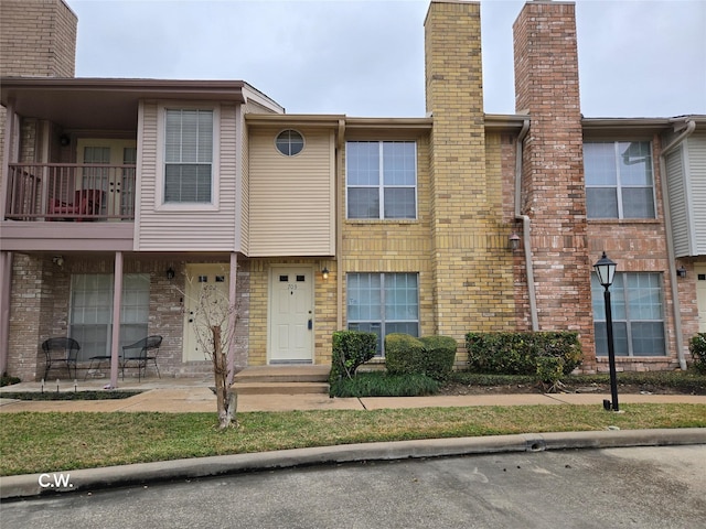 view of property with a balcony and a patio area