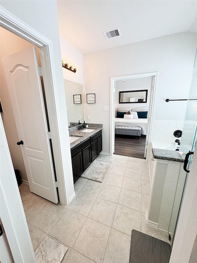 bathroom featuring vanity, tile patterned flooring, and a tub