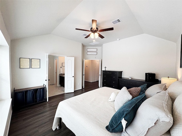 bedroom featuring dark wood-type flooring, ceiling fan, vaulted ceiling, and ensuite bath