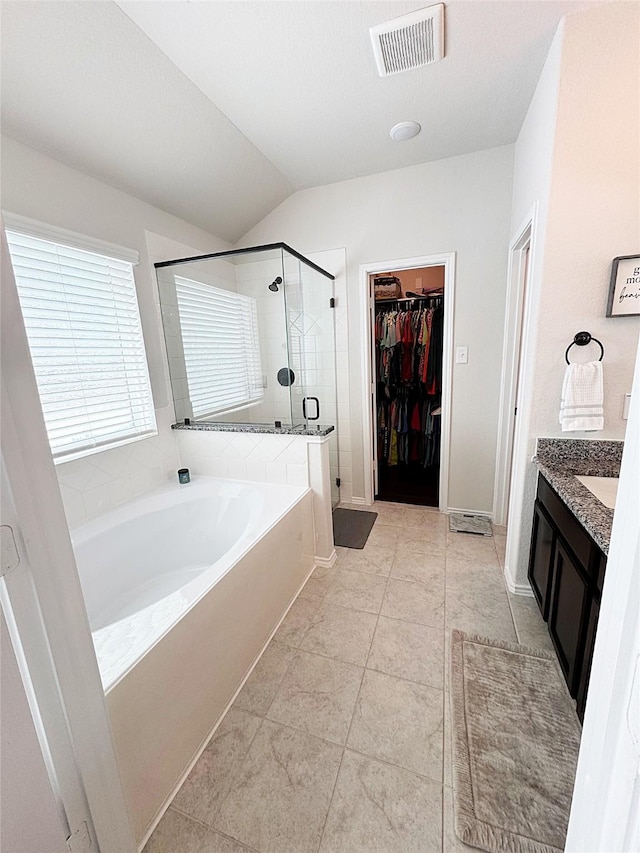 bathroom with lofted ceiling, vanity, shower with separate bathtub, and tile patterned floors