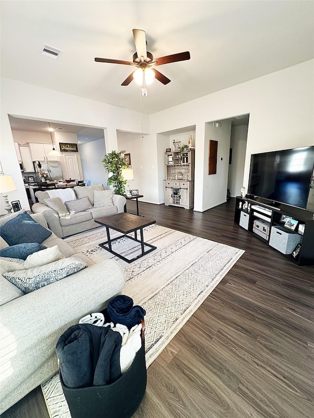 living room with ceiling fan and dark hardwood / wood-style floors