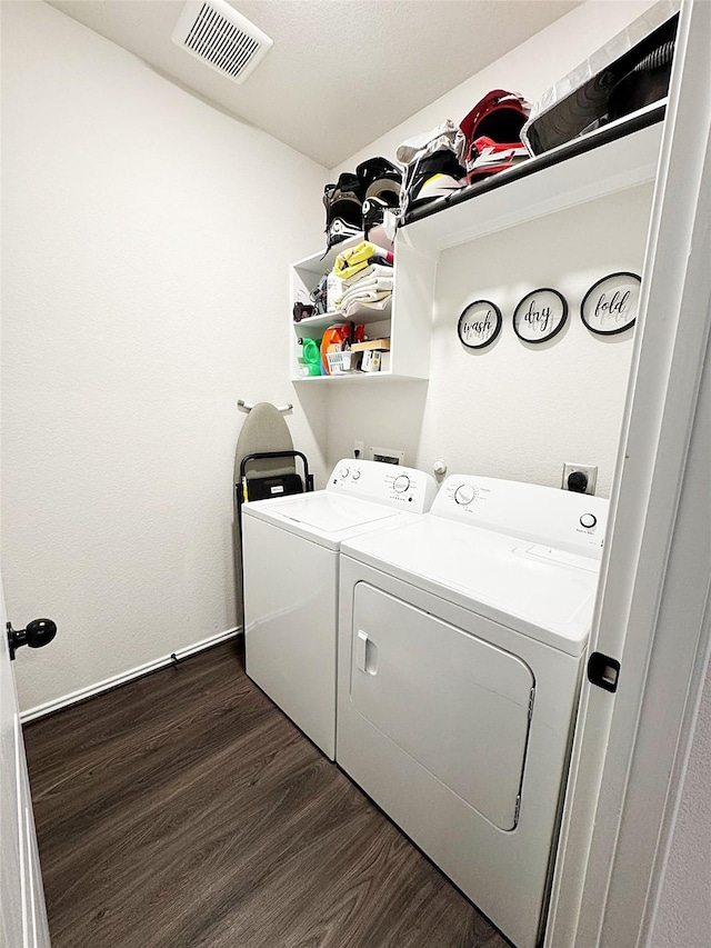 laundry room with dark wood-type flooring and washer and dryer