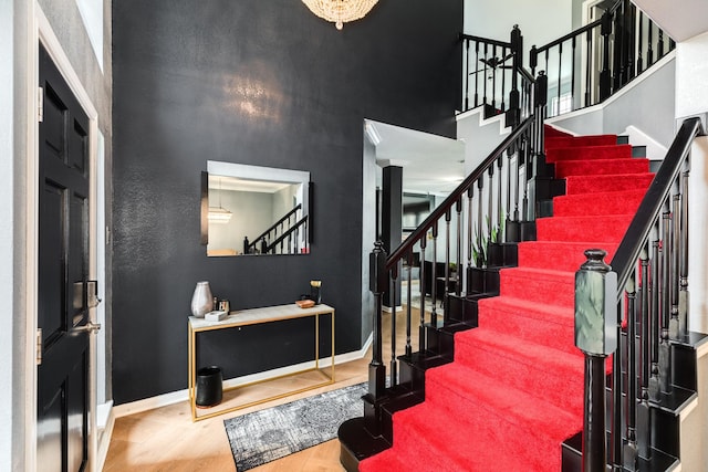 stairway featuring a towering ceiling and hardwood / wood-style floors