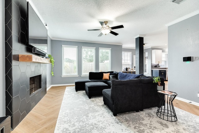 living room featuring ceiling fan, ornamental molding, and a textured ceiling