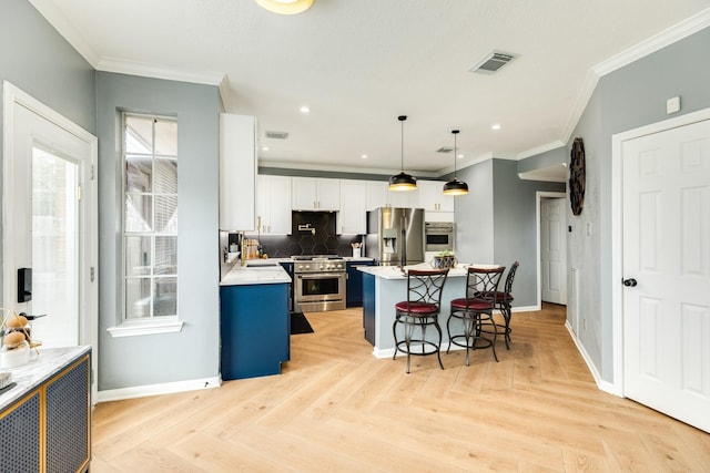 kitchen with a kitchen island, appliances with stainless steel finishes, white cabinetry, a kitchen bar, and hanging light fixtures