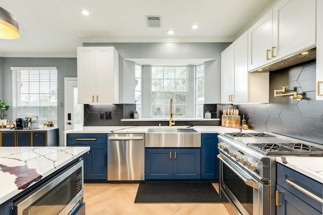 kitchen featuring blue cabinetry, sink, crown molding, appliances with stainless steel finishes, and white cabinets