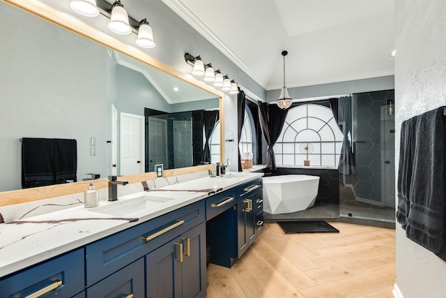 bathroom with lofted ceiling, hardwood / wood-style floors, vanity, ornamental molding, and separate shower and tub