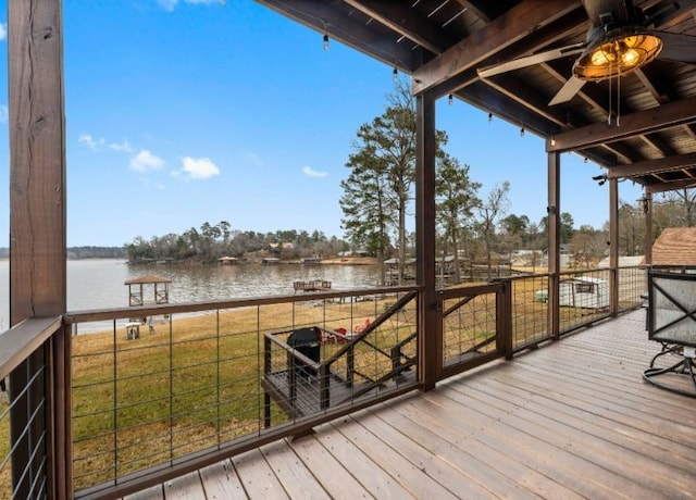 wooden terrace featuring ceiling fan and a water view