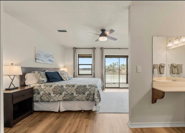 bedroom with ceiling fan, ensuite bath, access to outside, and wood-type flooring