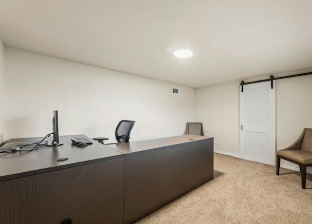 office featuring light carpet and a barn door