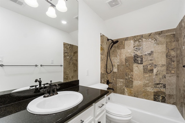 full bathroom with vanity, tiled shower / bath, and toilet