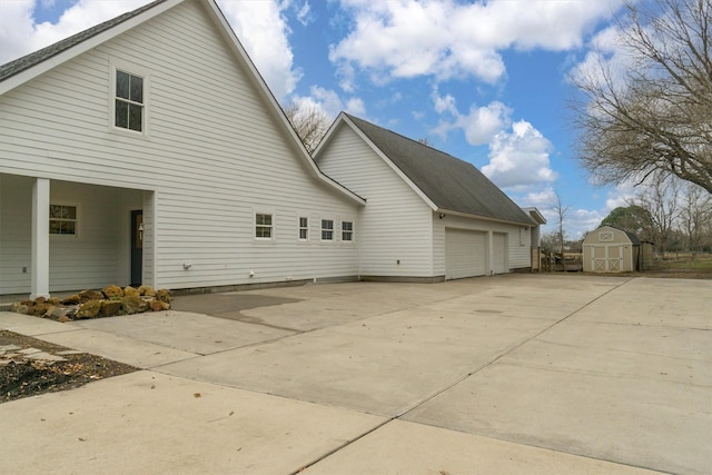 view of side of home featuring a storage shed and a garage