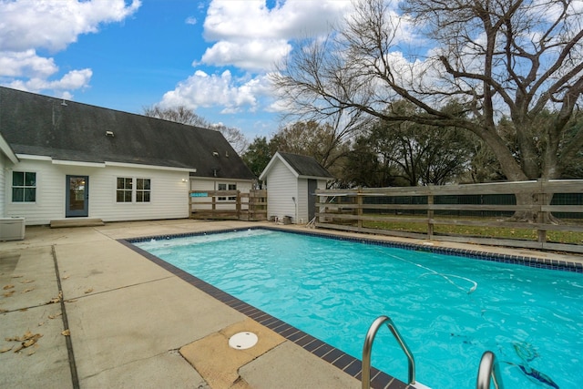 view of pool featuring a patio and a shed