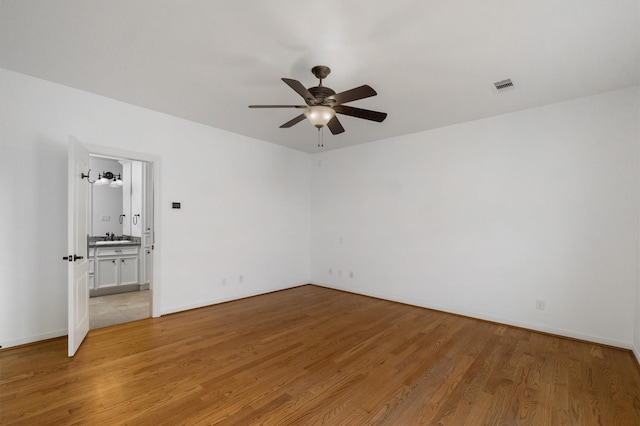 spare room with ceiling fan, sink, and light hardwood / wood-style floors