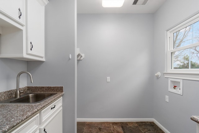 clothes washing area featuring hookup for a washing machine, sink, and cabinets