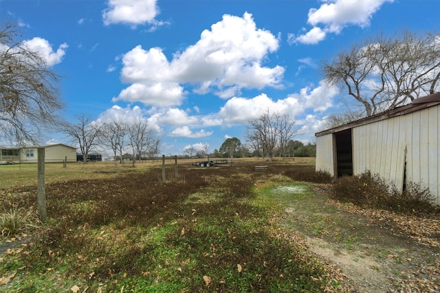 view of yard featuring an outdoor structure and a rural view