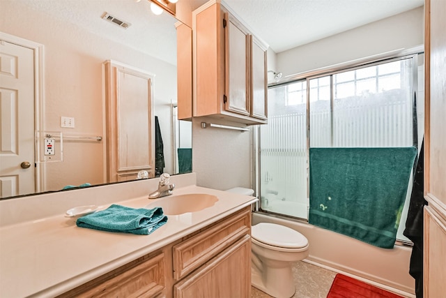 full bathroom with toilet, vanity, and bath / shower combo with glass door