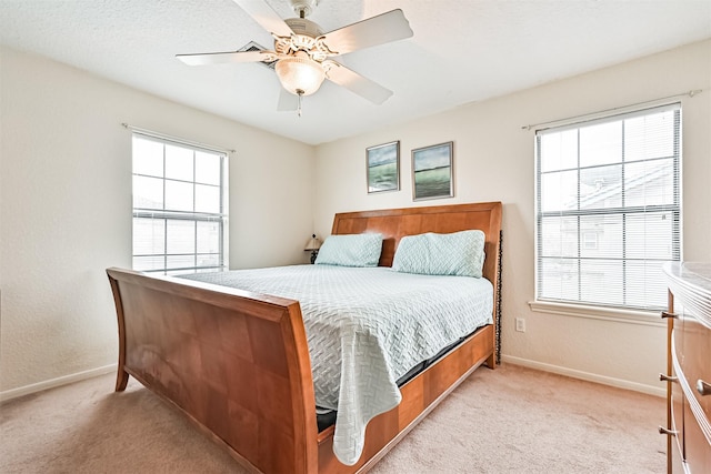 carpeted bedroom featuring ceiling fan and multiple windows