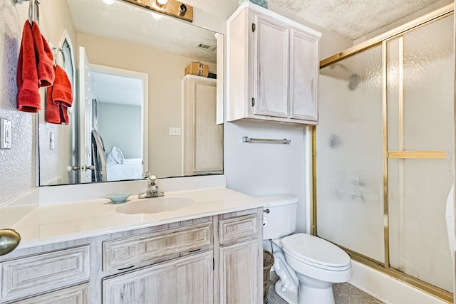 bathroom with vanity, toilet, and a shower with shower door