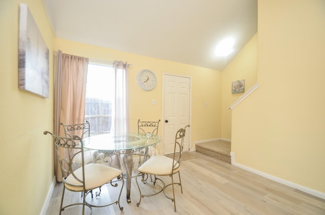 dining room featuring vaulted ceiling and light wood-type flooring