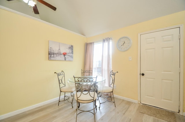 dining area featuring ceiling fan, vaulted ceiling, and light hardwood / wood-style flooring