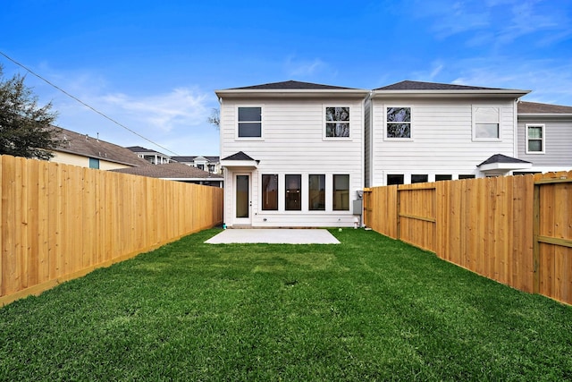 back of property with a yard and a patio