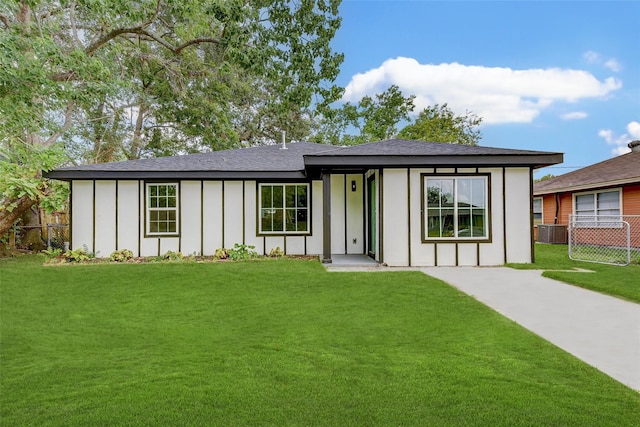 view of front of property with a front lawn and central air condition unit