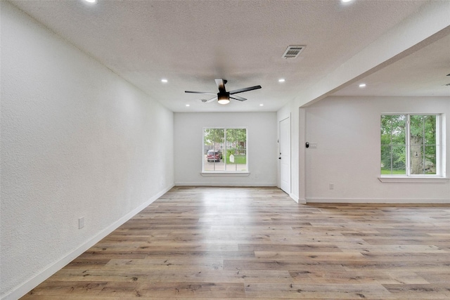 unfurnished room featuring ceiling fan, a textured ceiling, and light hardwood / wood-style floors