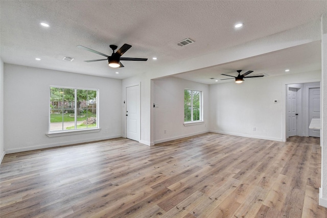 unfurnished living room featuring a textured ceiling, ceiling fan, and light hardwood / wood-style flooring