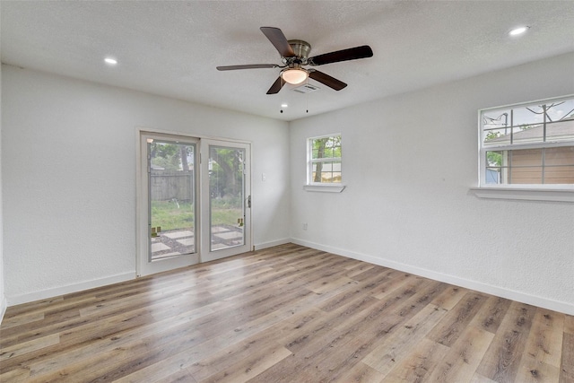 spare room featuring ceiling fan, light hardwood / wood-style floors, and a textured ceiling