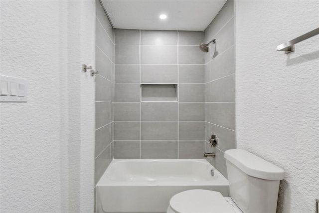 bathroom with tiled shower / bath and toilet