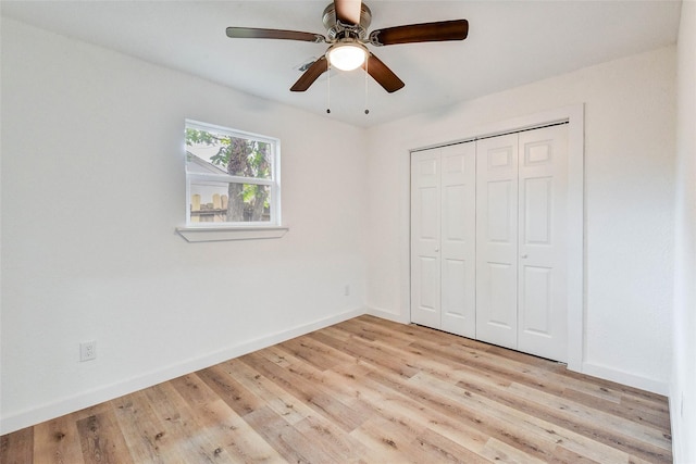 unfurnished bedroom featuring ceiling fan, a closet, and light wood-type flooring