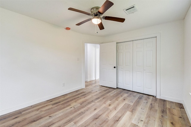 unfurnished bedroom with ceiling fan, light wood-type flooring, and a closet