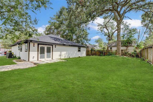 back of house featuring french doors, a yard, and central AC unit