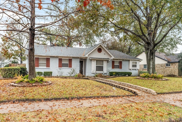 single story home featuring a front yard and brick siding