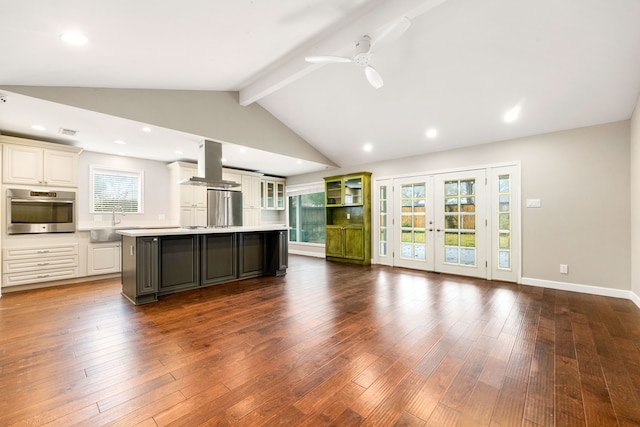 kitchen with dark hardwood / wood-style floors, island exhaust hood, a center island, and appliances with stainless steel finishes