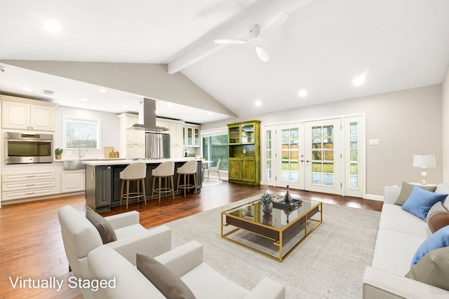 living room featuring vaulted ceiling with beams, recessed lighting, wood finished floors, baseboards, and french doors