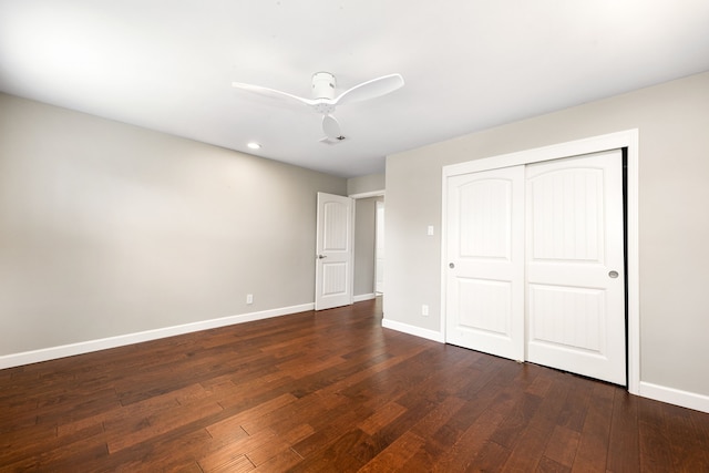 unfurnished bedroom featuring ceiling fan, dark hardwood / wood-style floors, and a closet