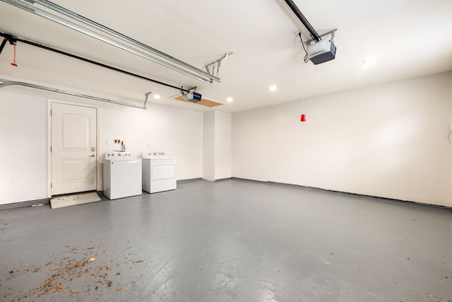 garage with independent washer and dryer and a garage door opener